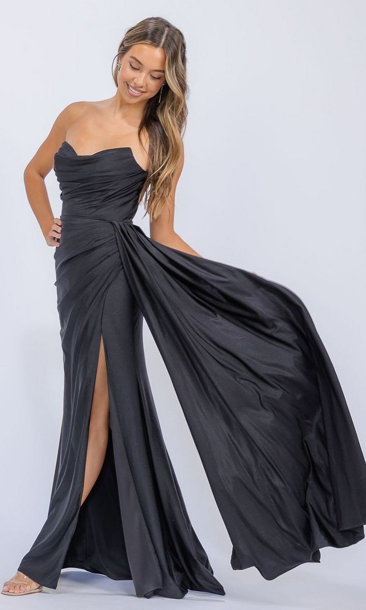 Woman models the Eureka EK178 Long Prom Dress—a strapless black gown with a high slit and flowing skirt—against a plain light backdrop.